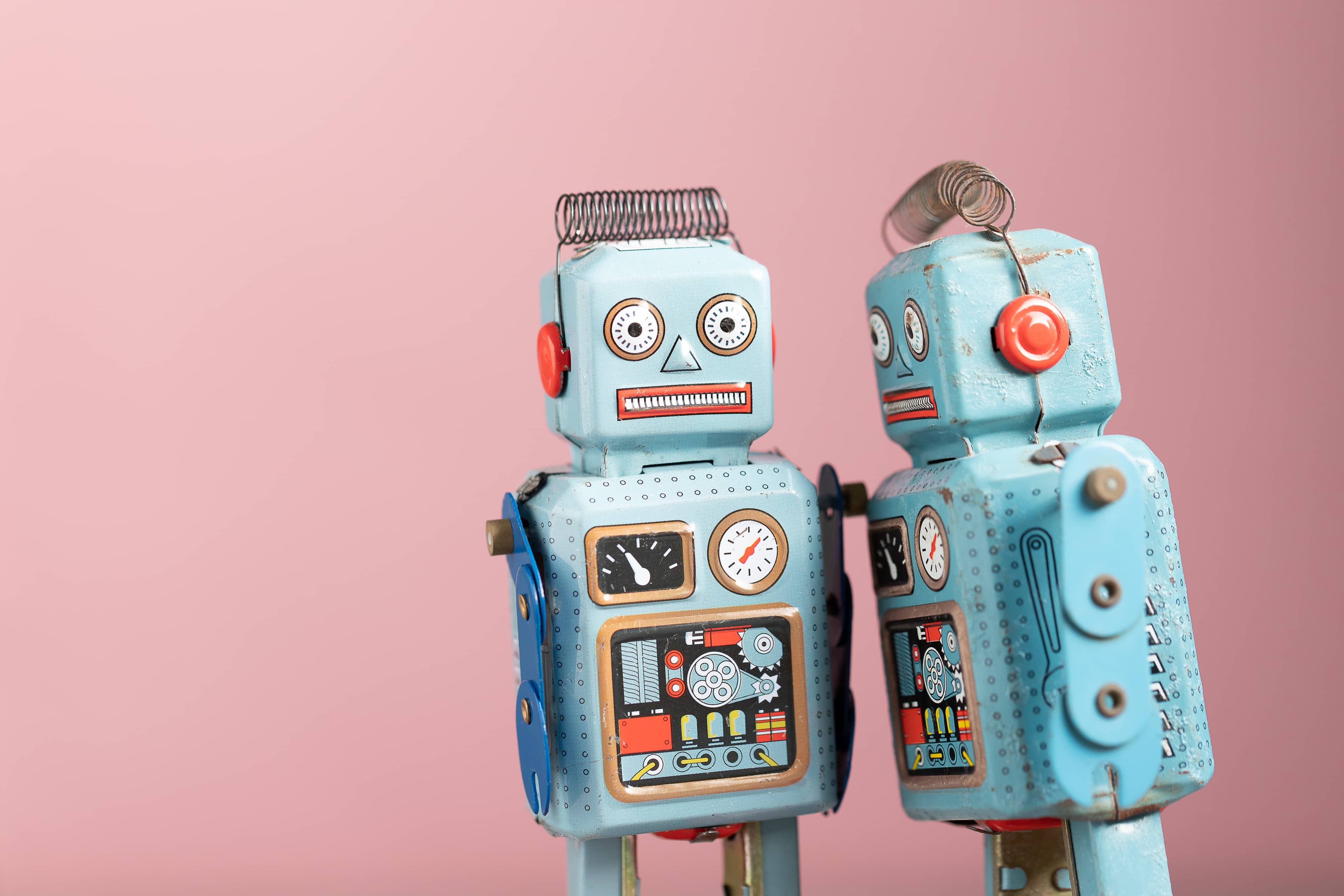 Two robots on a pink background