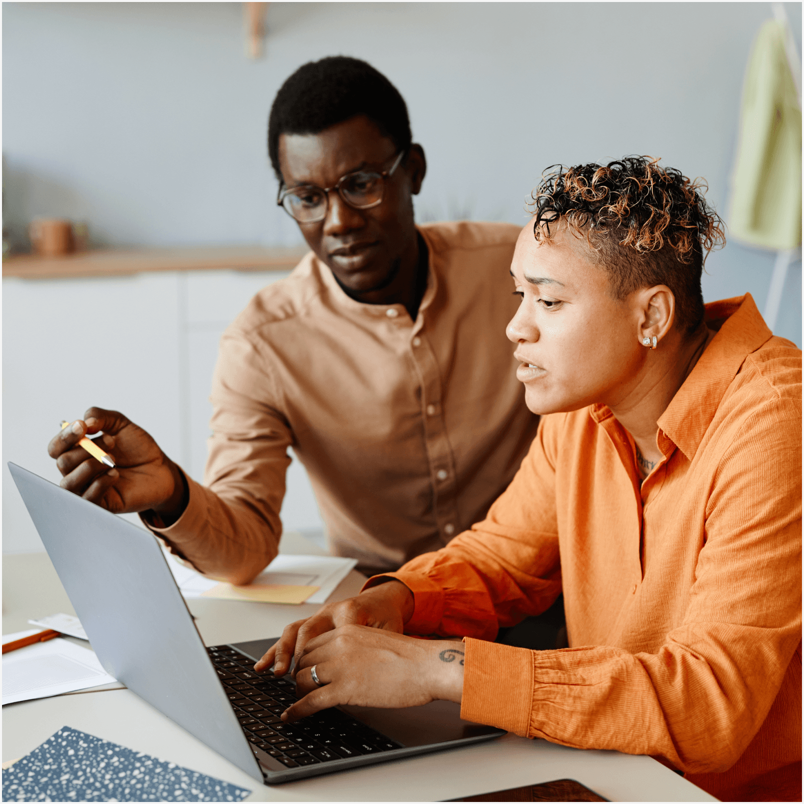 2 people looking over a laptop
