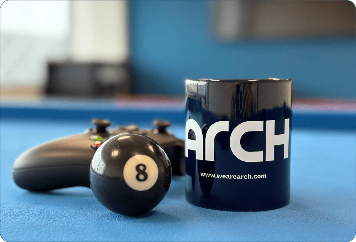 Arch mug and 8 ball on a pool table